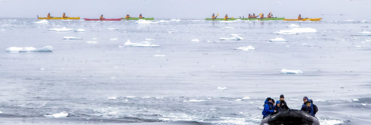 Kayaks in the water and Zodiacs exploring Kayaks in the water and Zodiacs exploring