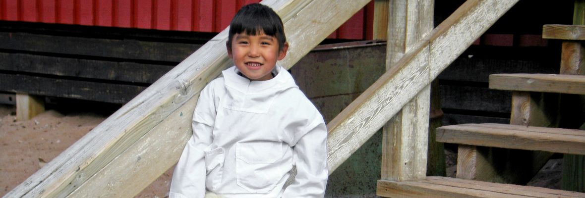 A Greenlandic child wearing polar bear fur pants