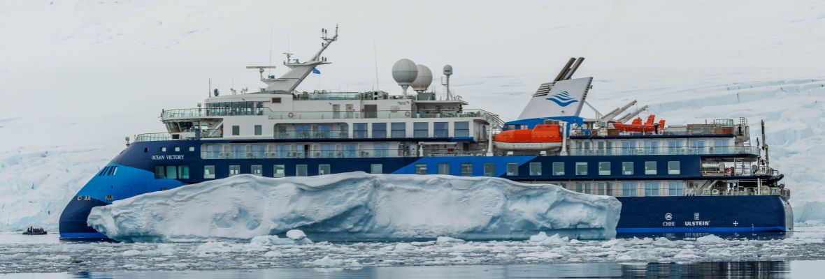 Ocean Victory cruises past an iceberg
