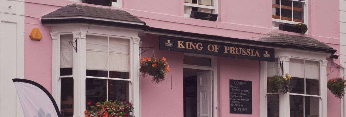 Pink building with flags hanging from the window 