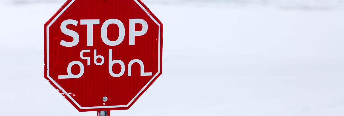 Bilingual stop sign showing both English and Inuktut in the Canadian north