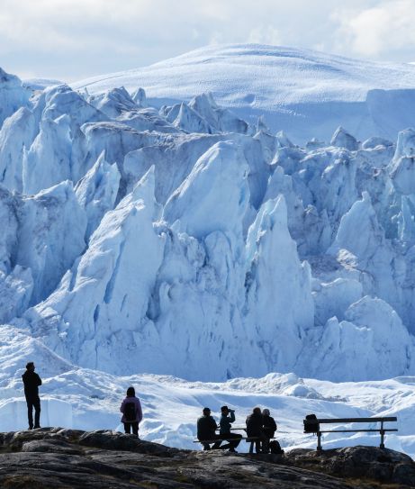 Visitors absorbing the majesty of Ilulissat Icefjord, Greenland 