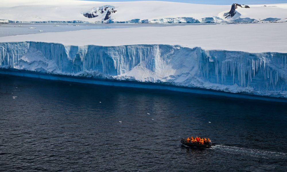 Zodiac cruising at a tabular iceberg Zodiac cruising at a tabular iceberg