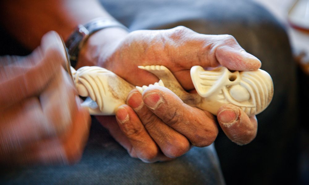 An artist carves a tupilak, East Greenland An artist carves a tupilak, East Greenland