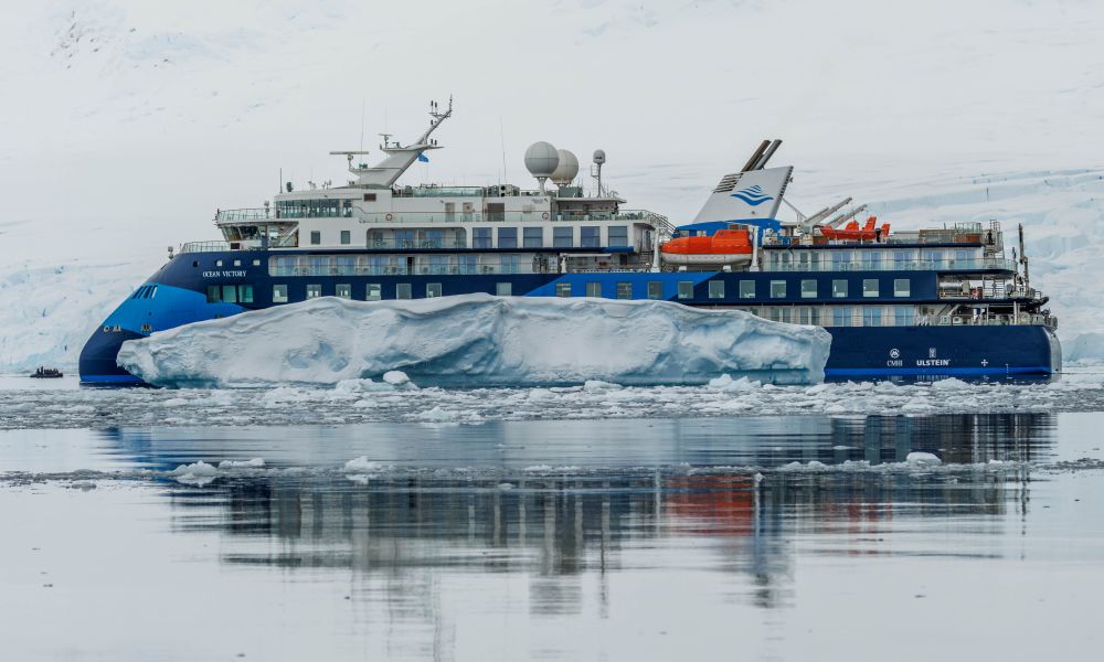 Ocean Victory cruises past an iceberg